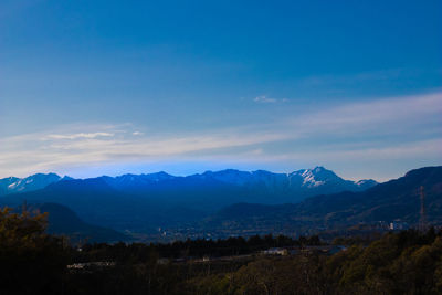 Scenic view of mountains against blue sky