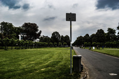 Information sign on field against sky