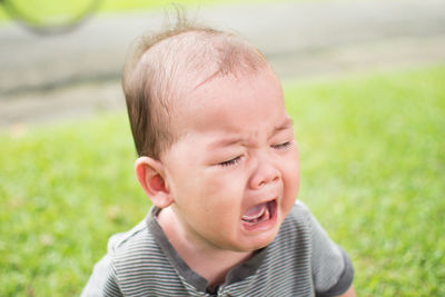 Close-up of cute baby boy crying at park