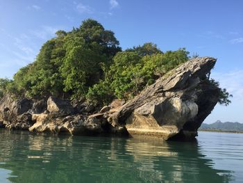 Rock formation by sea against sky