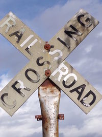 Low angle view of road sign against sky