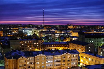 Illuminated cityscape against sky at night