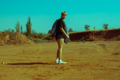 Side view of man standing on land against sky