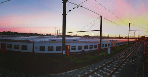 Railroad tracks against sky during sunset
