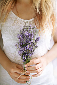 Midsection of woman holding lavender flower