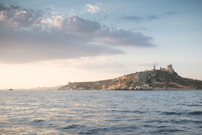 Lighthouse in sea against sky