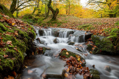 Long exposure of a waterfall flowing into the weir water river flowing at robbers bridge in exmoor 