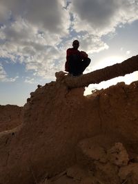 Low angle view of man standing on rock