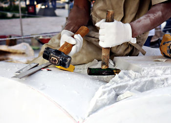 Midsection of worker cutting marble