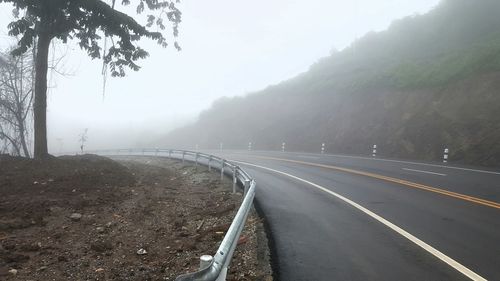 Road amidst trees against sky