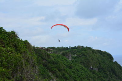 Low angle view of paragliding against sky