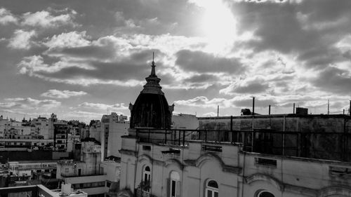 Buildings in city against cloudy sky