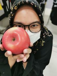 Portrait of woman holding apple