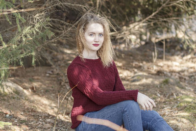 Portrait of young woman sitting on field