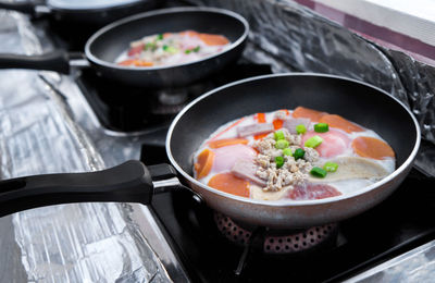 Fried eggs in pan with handle on table, top view