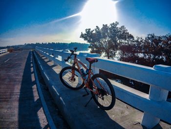 Bicycle parked by trees against sky