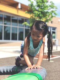 Girl kneeling on play equipment at playground