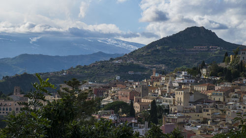 View of cityscape against cloudy sky