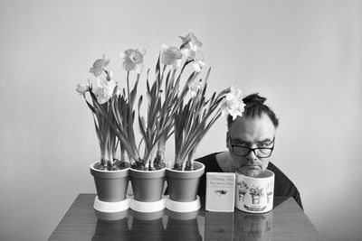 Portrait of man and woman in vase on table against wall