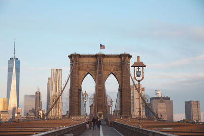 Street light brooklyn bridge in city against sky