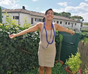 Portrait of smiling young woman standing against plants