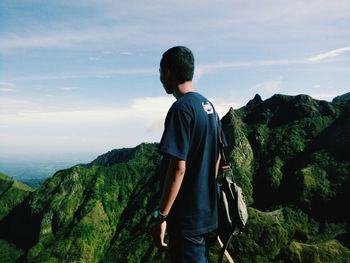 Man standing on mountain against sky