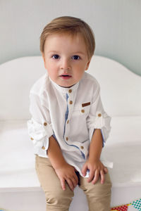 Child sitting on a wooden white cart in the studio as a birthday decoration