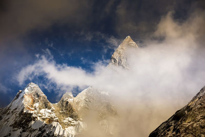 Low angle view of snowcapped mountains against sky