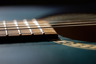 Close-up of guitar on table against black background