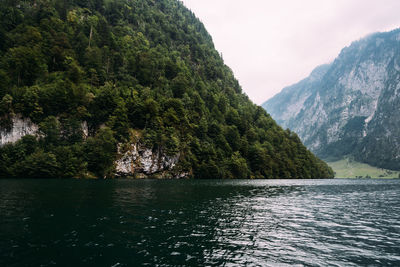 Scenic view of river by mountains against sky