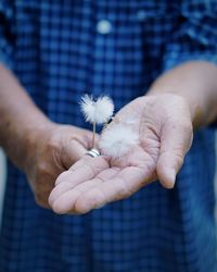 Close-up of man holding dandelions 