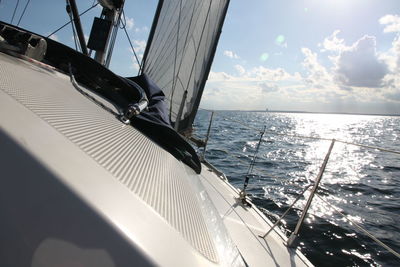 Close-up of sailboat sailing on sea against sky