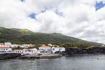 Scenic view of townscape by mountain against sky