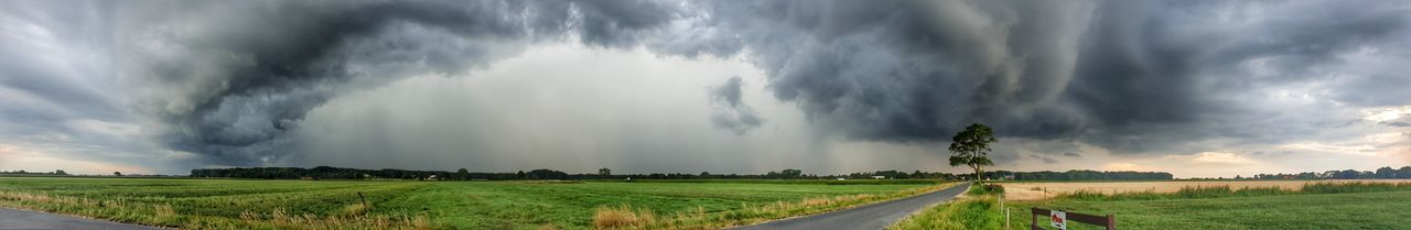 Panoramic shot of agricultural field against storm clouds