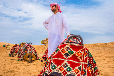 Midsection of person standing on desert against sky