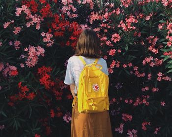Rear view of girl standing against multi colored flowers