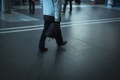 Low section of man walking on floor at night