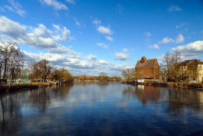 Panoramic view of temple by lake against sky