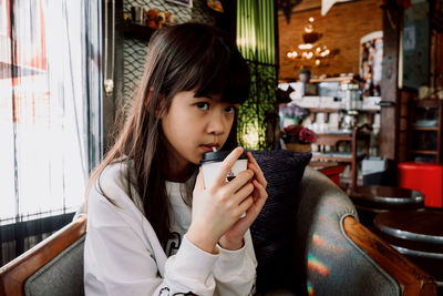 Portrait of girl drinking coffee in restaurant