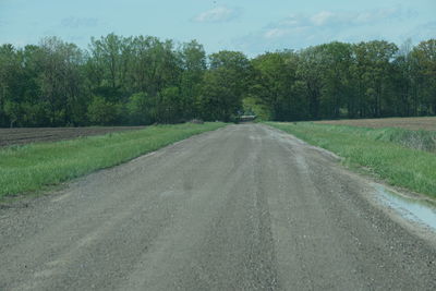 Road amidst trees against sky