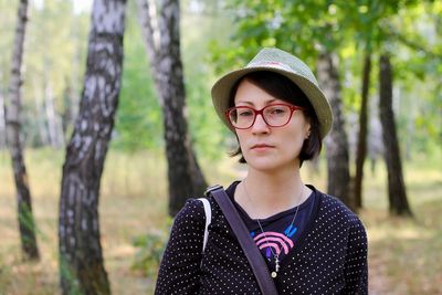 Portrait of smiling woman standing in forest