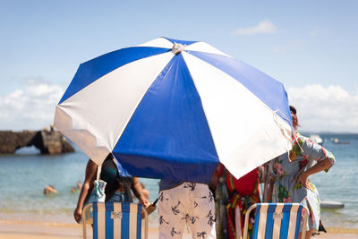 Rear view of woman with umbrella on beach