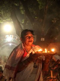 Women holding dia-oil lamp on hand at a smokey environment at rakher upobash 