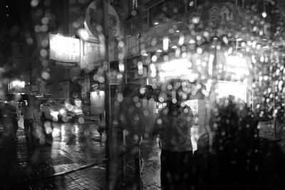 People walking on illuminated street at night