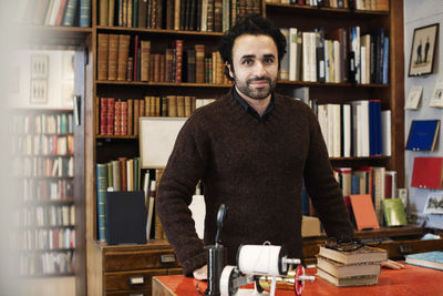 Portrait of young man standing at home