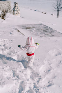 Portrait of woman skiing on snow covered field