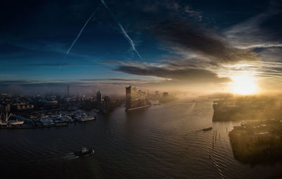 Aerial view of city buildings against sky during sunset