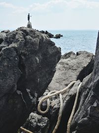 Rock formation on beach against sky