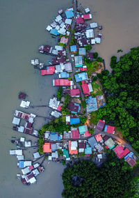 High angle view of houses by trees and buildings in city