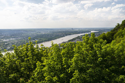 River rhein in western germany flowing along the city against the sky with clouds. visible ships.